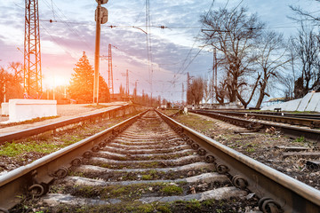 Railway road, rails and tracks going into the distance of evening sunset.