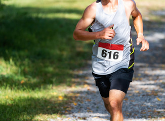 Runner racing on gravel during cross country race