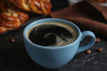 Delicious coffee and pastries on black table