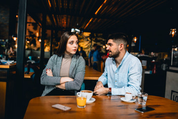 couple arguing while sitting in cafe bar