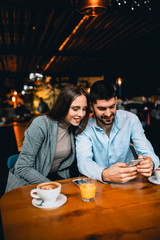 couple using smartphone in restaurant