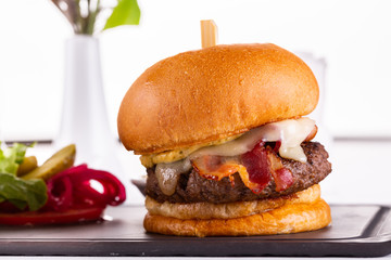 Hamburger with meat and bacon, served with salts