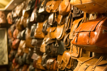 Leather handbags in the shop of a merchant in the souk of the medina of Fes in Morocco