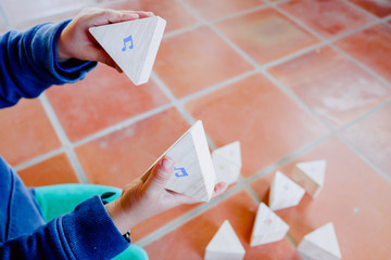 Child holding some wooden blocks with musical notes to learn music theory.