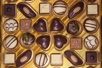 Variety of chocolate candies and roses. Luxurious box of chocolates.Decorated chocolate candies, bitter and white chocolate candies filled with different types of creams. Perfect design and style of c