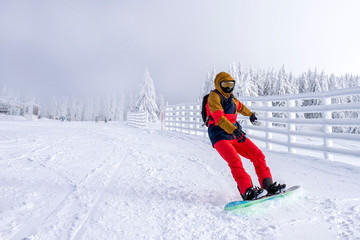 Fototapeta na wymiar Snowboarder enjoys snowboard ride in mountain ski resort