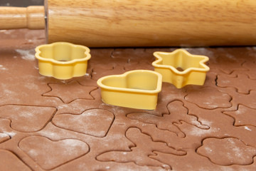 Cutting figures from the dough using special stencils for making ginger Christmas cookies. Home, family prepare for the holidays concept