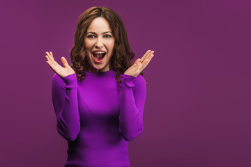 suprised woman standing with open arms on purple background