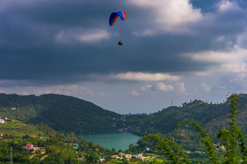 Paragliding in a picturesque valley, Naukuchiatal Lake at the back, Uttarakhand, India