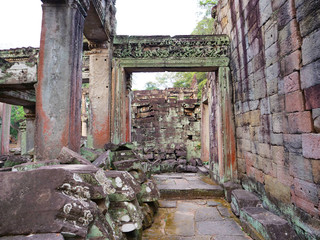 Demolished stone rock door frame at Preah Khan temple Angkor Wat complex, Siem Reap Cambodia. A popular tourist attraction nestled among rainforest.