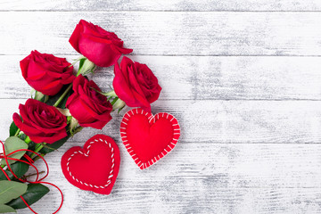 Red roses and hand made hearts on wooden white background. The concept of Valentine Day. Copy space for your text