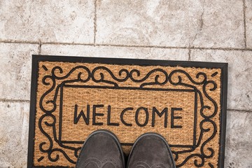 Welcome cleaning foot carpet with shoes and a shoe print