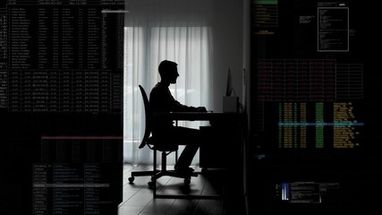 Man sits down at his desk in a dark room and starts programing / hacking / working - Digital generated overlay - Powered by Adobe