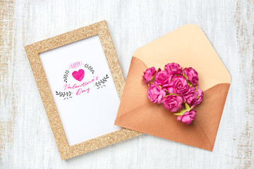 Mockup golden picture frame for Valentines day concept. Flat lay Top view of mock up photo frame with craft rose flowers in envelope on grunge white wood background.