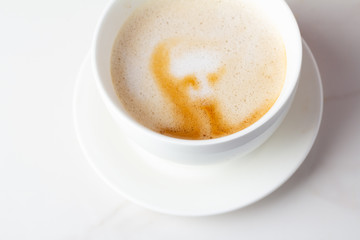 cappuccino coffee in a white mug on a white background close-up