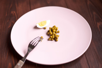 Fototapeta na wymiar Peas and chicken egg on a plate. Poor, poor food. The concept of diet, malnutrition.