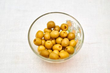 Stuffed olives in a cup on a light background