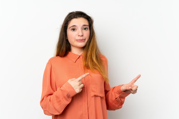 Young brunette girl over isolated white background frightened and pointing to the side