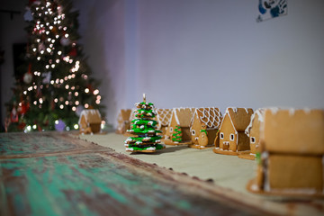 Christmas tree made of gingerbread cookies, with gingerbread houses on the background