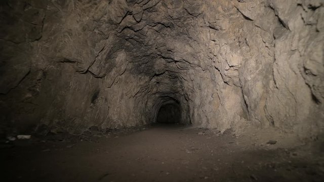 Speleology artificial cave dark tunnel excavation underground. Old adit for the extraction of metal and rocks