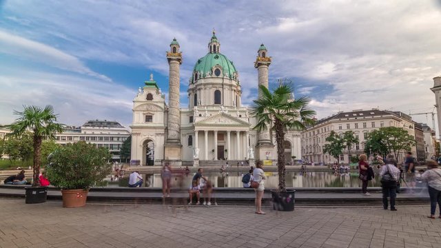 Karlskirche on the Karlsplatz square timelapse hyperlapse in Vienna, Austria. People walking and sitting at fountain. It is a catholic church, also called Rektoratskirche, with a typical baroque