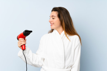 Young woman in a bathrobe with hair hairdryer with happy expression