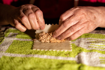 Rolling cannelloni with minced meat in a traditional way, typical gastronomy of Catalonia.