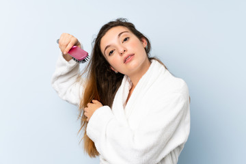 Young woman in a bathrobe with with hair comb.