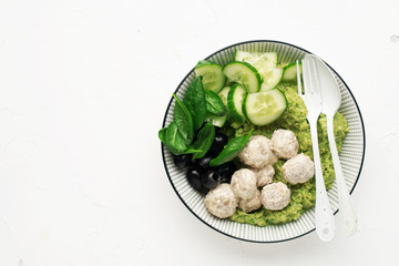 Keto paleo diet lunch, mashed broccoli with butter, meat balls in sour cream sauce, spinach, cucumber, olives. Low carbohydrate. High fats, a lot of fiber. Top view,