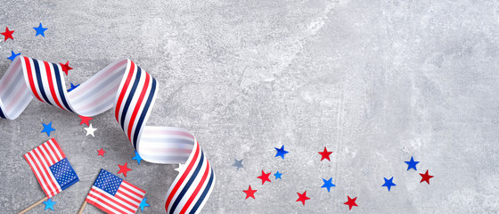 Obraz premium Happy Presidents day sale banner mockup. American flags, grosgrain ribbon, confetti stars on concrete stone. USA Memorial day, Veterans day or Independence day concept.