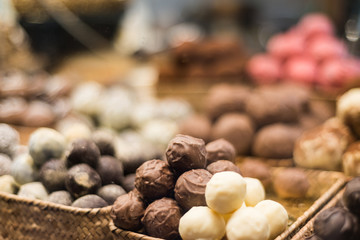 Assorted chocolate bonbons seen through a display window