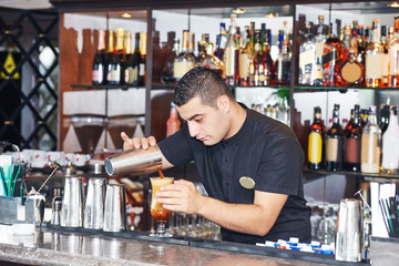 Barman worker making cocktail in bar