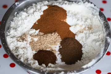 Allspice, cinnamon, cloves and ground nutmeg with flour in a stainless steel bowl