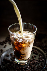 pouring milk into iced espresso