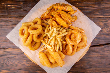Assembly of potatoes, cheese sticks, onion rings and squid rings