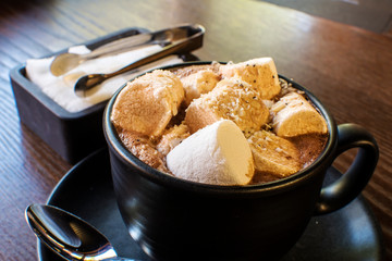 Hot cocoa with mini marshmallows on wooden board