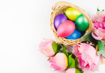 happy Easter, colored eggs in a basket and spring flowers on a white background, spring Orthodox Christian and Catholic holiday, banner with space for text