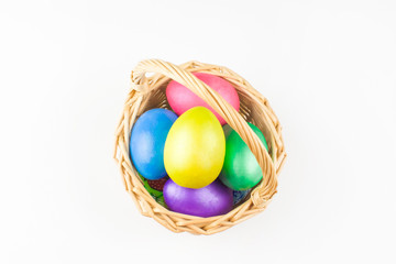 happy Easter, colored eggs in a basket and spring flowers on a white background, spring Orthodox Christian and Catholic holiday, banner with space for text