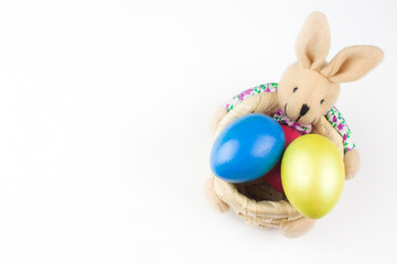 happy Easter, colored eggs in a basket and spring flowers on a white background, spring Orthodox Christian and Catholic holiday, banner with space for text