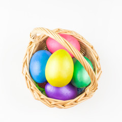 happy Easter, colored eggs in a basket and spring flowers on a white background, spring Orthodox Christian and Catholic holiday, banner with space for text