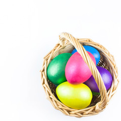 happy Easter, colored eggs in a basket and spring flowers on a white background, spring Orthodox Christian and Catholic holiday, banner with space for text