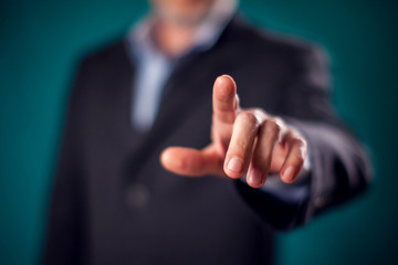 Businessman in suit pressing virtual button or pointing at something