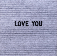 Fototapeta premium The words Love You on grey felt letter board