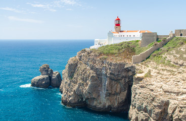 Fototapeta na wymiar Portugal, Algarve, view of cliffs of Moher and Atlantic Ocean, white red lighthouse, lighthouse near Sagres in Portugal, Cape St. Vincent on a sunny day with The azure Atlantic in the background