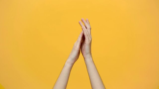 Woman hands clapping applause and showing two thumbs up gesture isolated over yellow background in studio. Copy space for advertisement. With place for text or image. Advertising area, mock up.