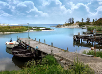 Tranquil picturesque small boat marina in calm condition with a looming storm further out at sea - 314329104