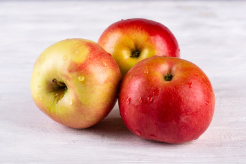 Apples red-yellow on white wooden background