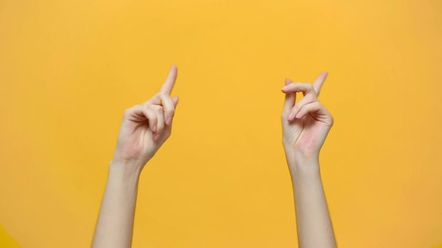 Woman hands snaps her fingers to music rhythm gesture isolated over yellow background in studio. Copy space for advertisement. With place for text or image. Advertising area, mock up.