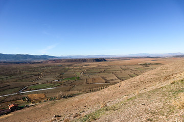 landscape with valley full of fields in sierra nevada mountains and blue sky