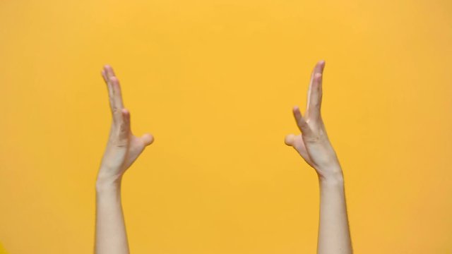 Woman two hands bumping fists hit bang gesture isolated over yellow background in studio. Copy space for advertisement. With place for text or image. Advertising area, mock up. Friendship and greeting